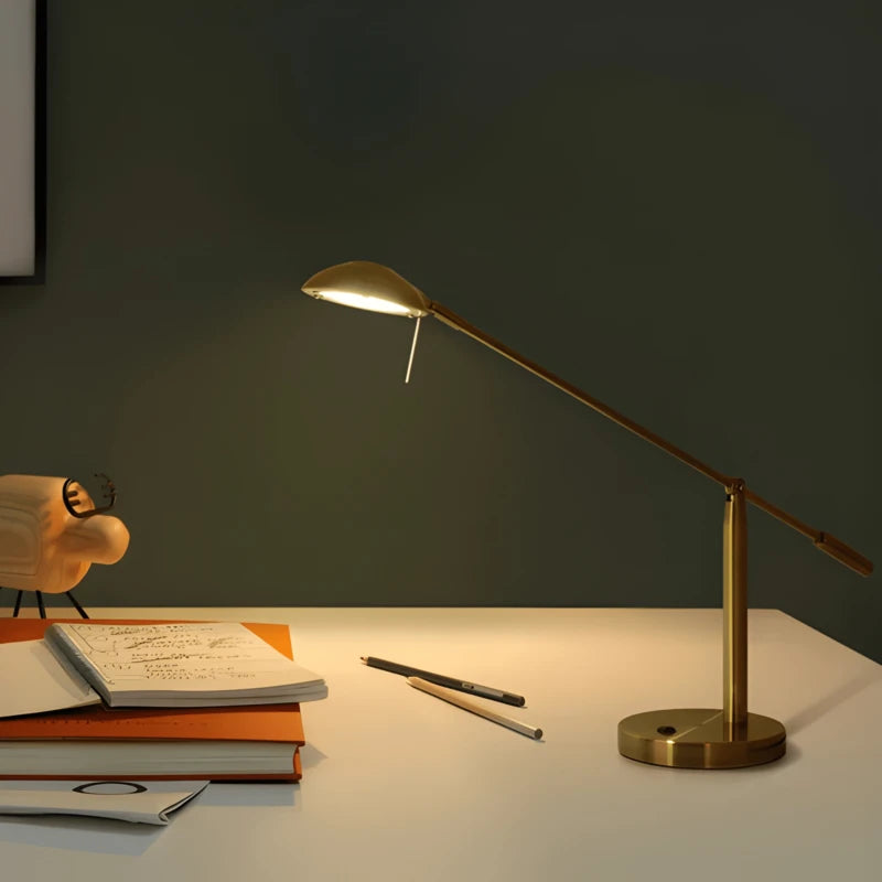 Lampe de bureau dorée articulée qui éclaire un bureau
