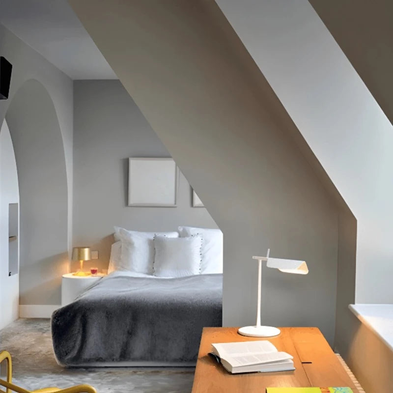 Lampe de bureau LED blanche design italien sur un bureau en bois dans une chambre