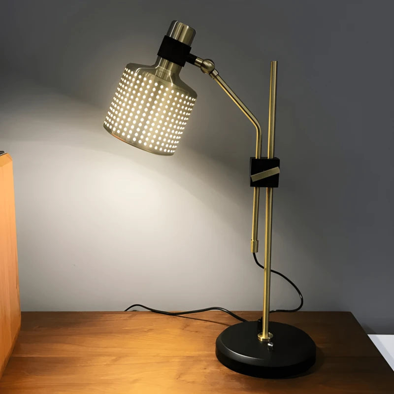Lampe de bureau métal doré qui éclaire un espace de travail en bois