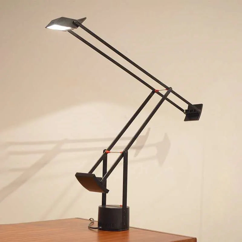 Lampe de Bureau Articulée Tizio installée sur un espace de travail en bois clair