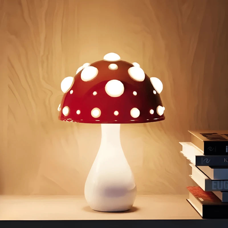 Lampe de bureau design champignon rouge & blanche placée sur un espace de lecture en bois