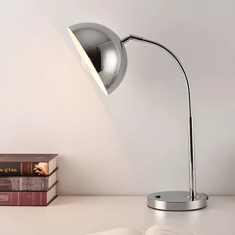 Lampe de bureau vintage en argent placée sur un bureau blanc