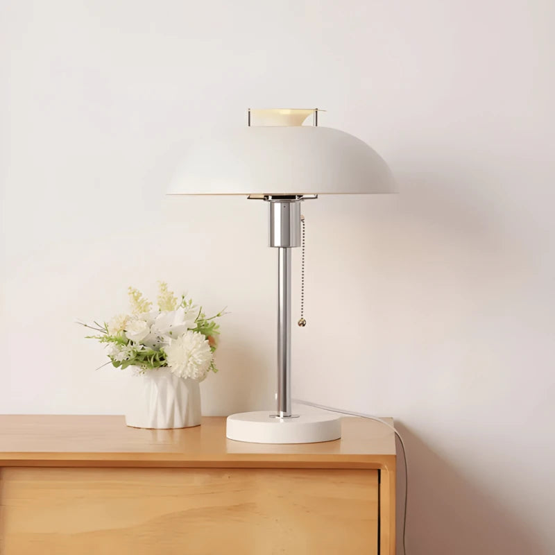 Lampe Bauhaus Élégance blanche placée sur un meuble bas en bois clair
