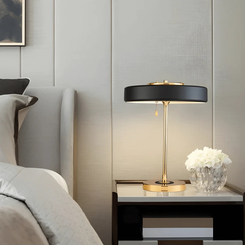 Lampe de Bureau Design Horizon noire et dorée sur une table de chevet 