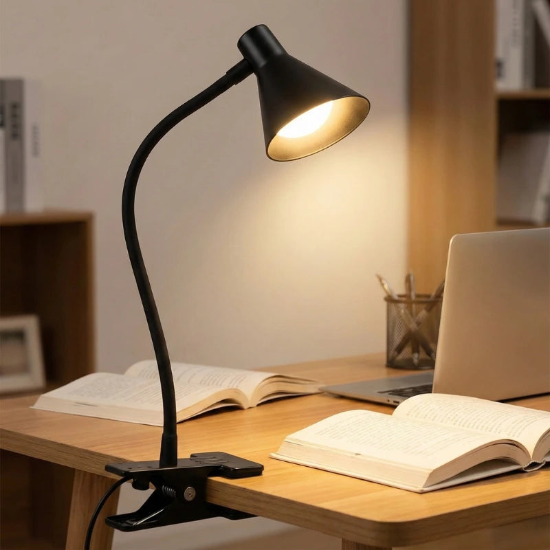 Lampe de Bureau LED à Pince Lumia noire sur la gauche d'un bureau en bois clair