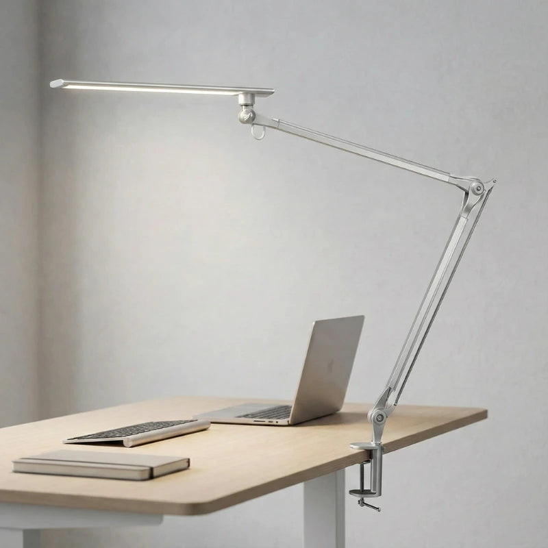 Lampe de Bureau LED à Pince Métallique en argent pincée sur un bureau en bois