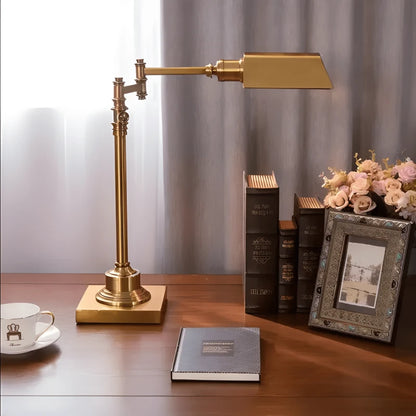 Lampe de bureau vintage cuivrée rectangle qui éclaire trois livres