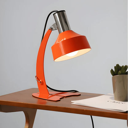 Lampe de bureau vintage en métal située sur un espace de travail en bois foncé