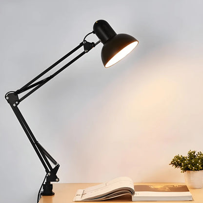 Lampe de bureau architecte à pince noir montée sur un espace de lecture