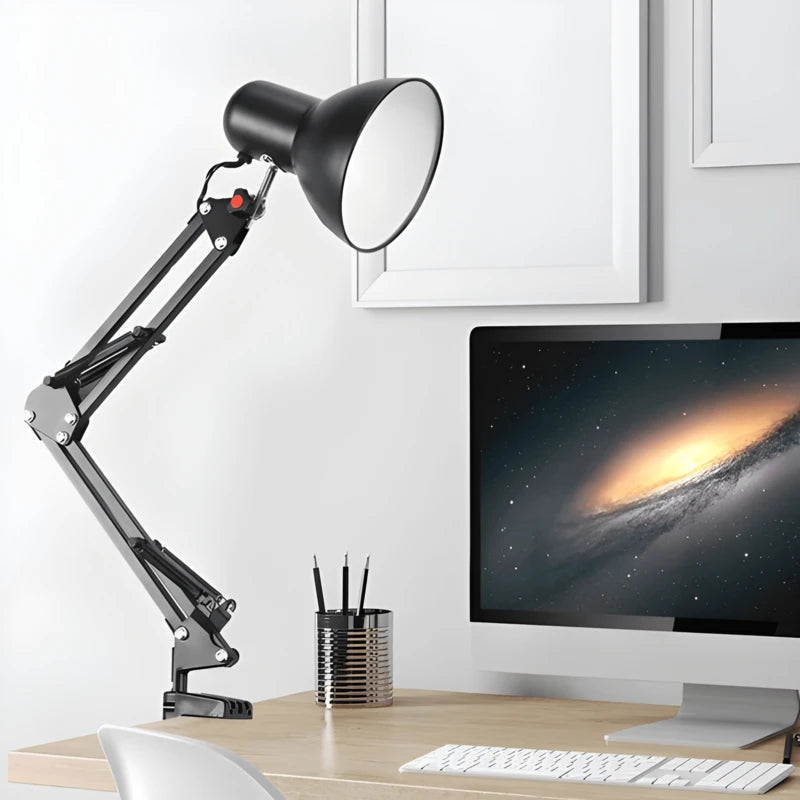 Une lampe de bureau architecte à pince noire accrochée à un bureau en bois clair
