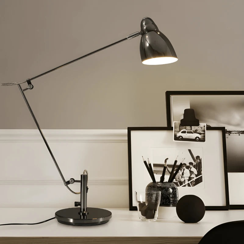 Lampe de bureau articulée chromée noir nacré installée sur un bureau 