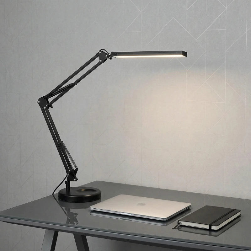 Lampe de Bureau Articulée en Métal configurée sur un espace de travail en verre