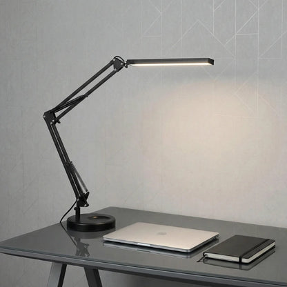 Lampe de Bureau Articulée en Métal configurée sur un espace de travail en verre