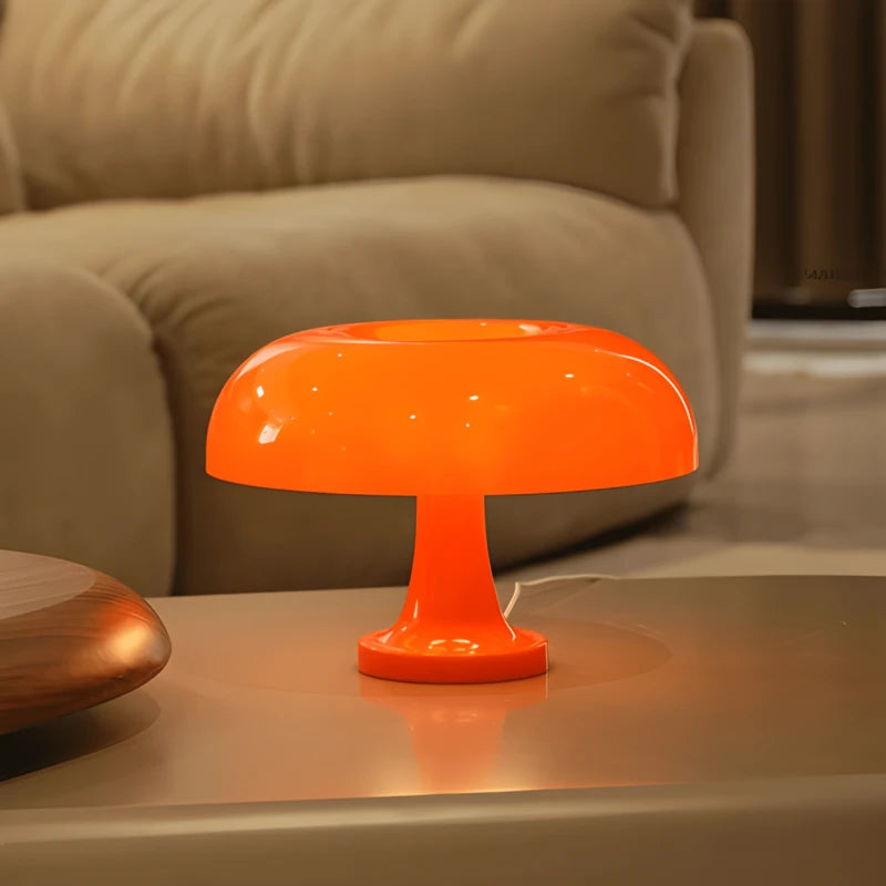 Une lampe de bureau champignon orange placée sur un bureau bas