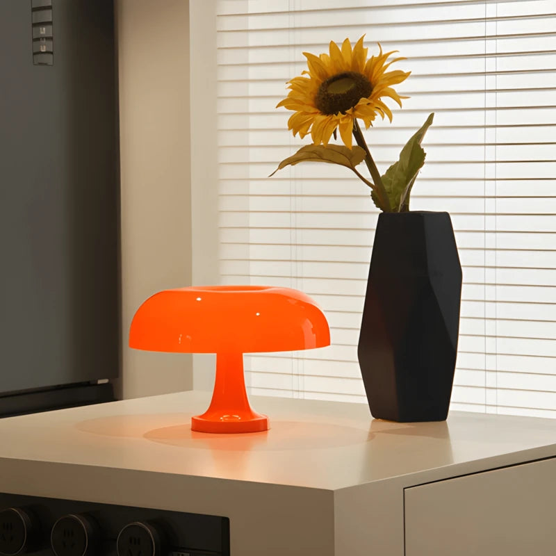 Une lampe de bureau champignon orange éclairante un espace blanc