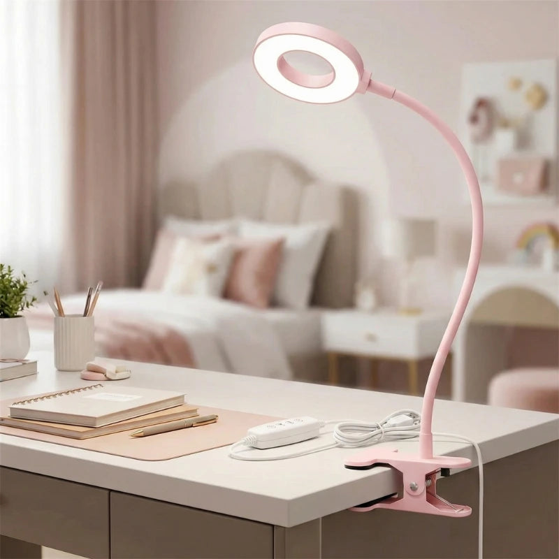 Lampe de Bureau À Pince pour Enfants rose claire posée sur la droite d'un bureau blanc