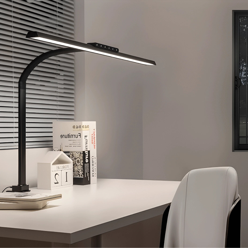Lampe de Bureau LED à Pince Panoramique Intensité Variable placée sur un bureau blanc