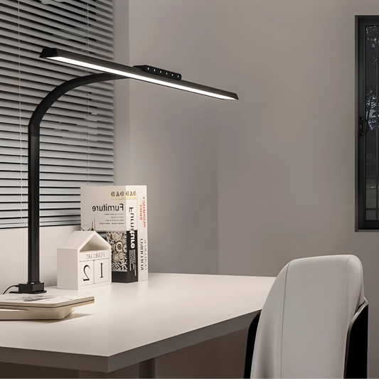 Lampe de Bureau LED à Pince Panoramique Intensité Variable placée sur un bureau blanc