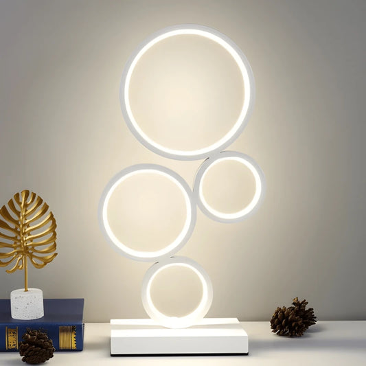 Lampe de Bureau LED Anneaux blanc placée sur un espace de lecture blanc