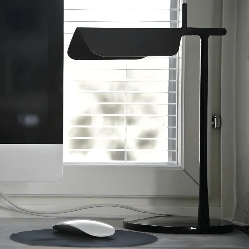 Lampe de bureau LED noire design italien sur un bureau minimaliste 