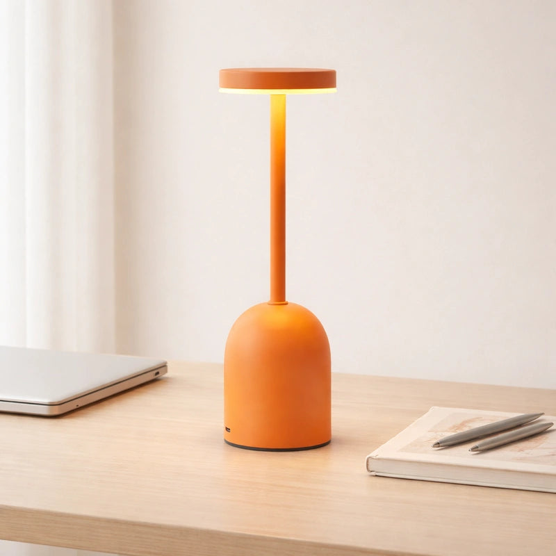 Lampe de Bureau LED à Intensité Variable orange sur un bureau en bois