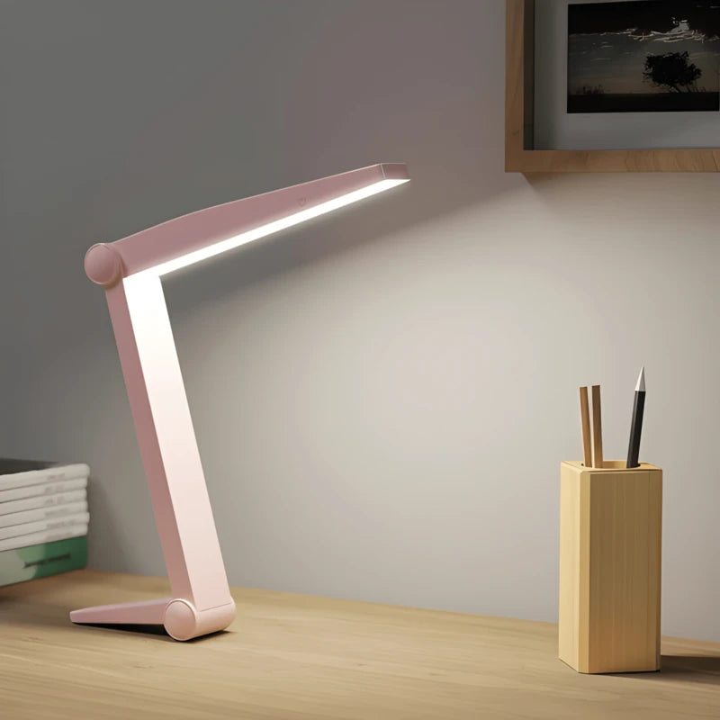 Lampe de bureau LED lecture rose sur un bureau en bois