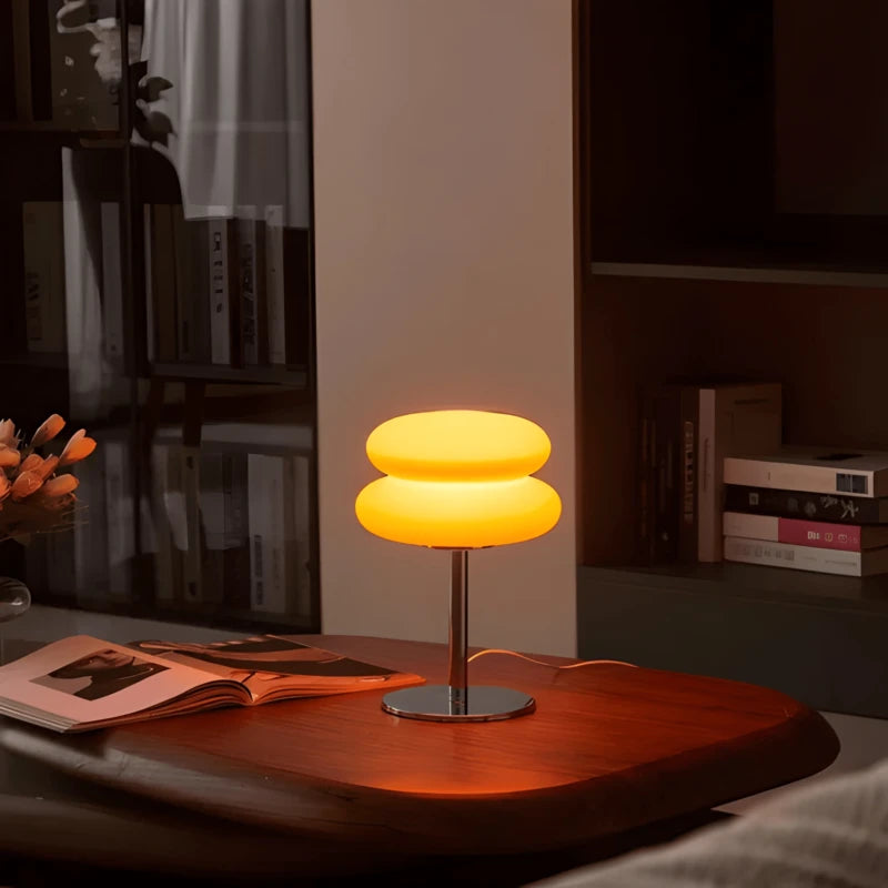 Lampe de bureau LED macaron allumée sur un espace de travail en bois