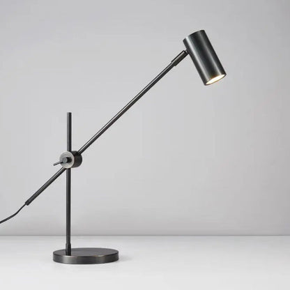 Lampe de bureau led noire mate sur un bureau blanc