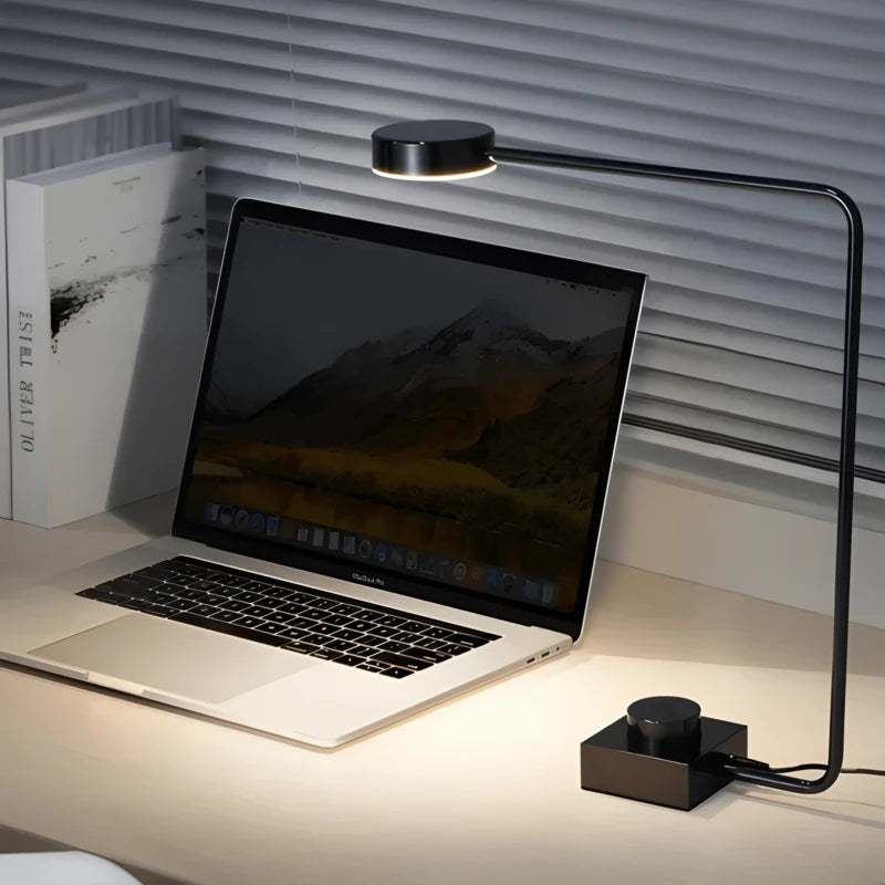 Lampe de Bureau LED Minimaliste Art éclairante un ordinateur portable placé sur un bureau blanc