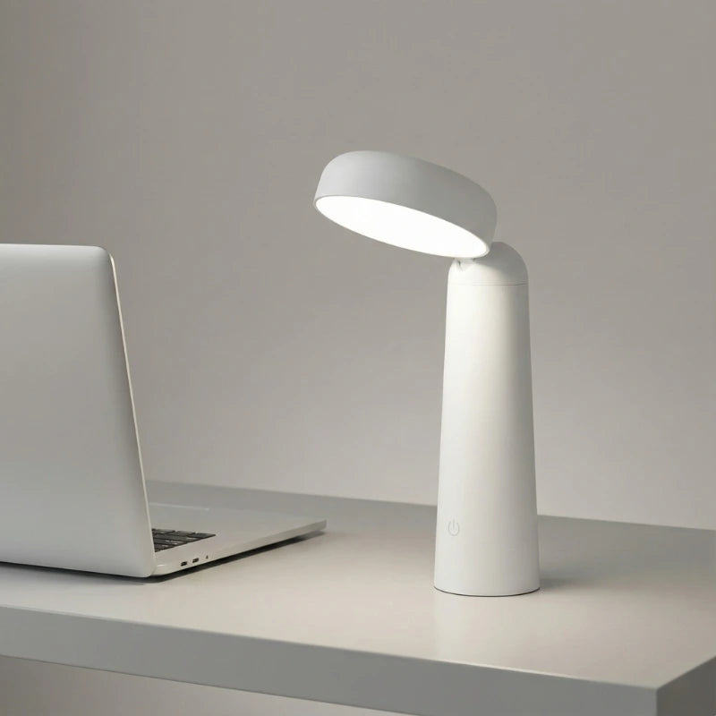 Lampe de Bureau LED Minimaliste Sans Fil blanche placée sur un espace de travail blanc
