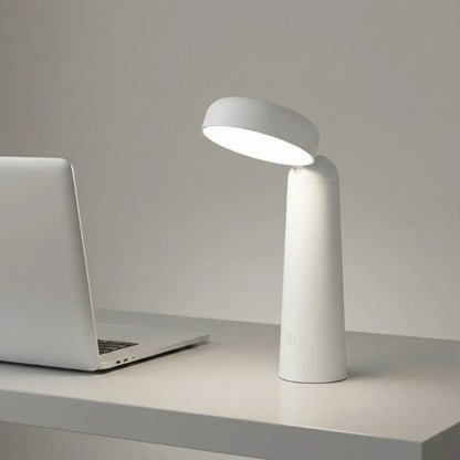 Lampe de Bureau LED Minimaliste Sans Fil blanche placée sur un espace de travail blanc