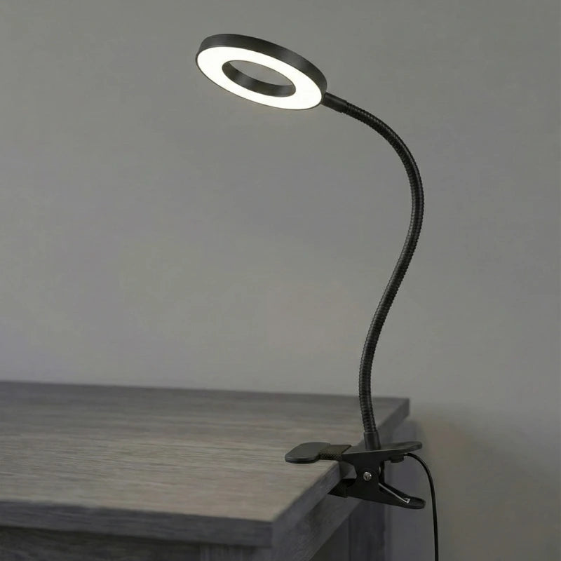 Lampe de Bureau LED USB Col de Cygne à Pince noire au-dessus d'un espace de travail en bois