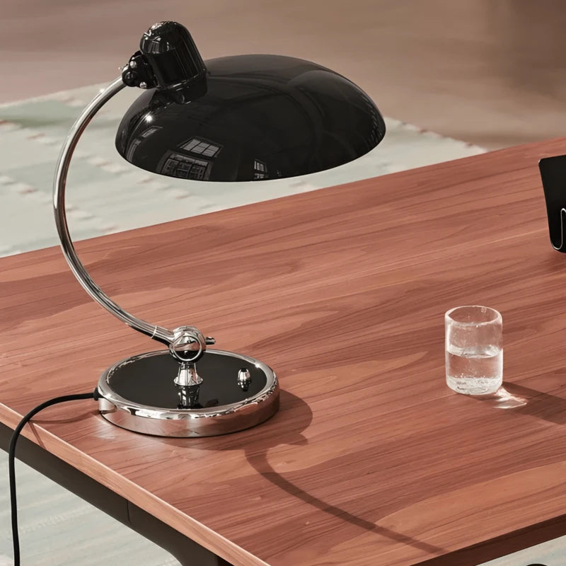Lampe de bureau style années 50 noire sur un espace de travail en bois foncé