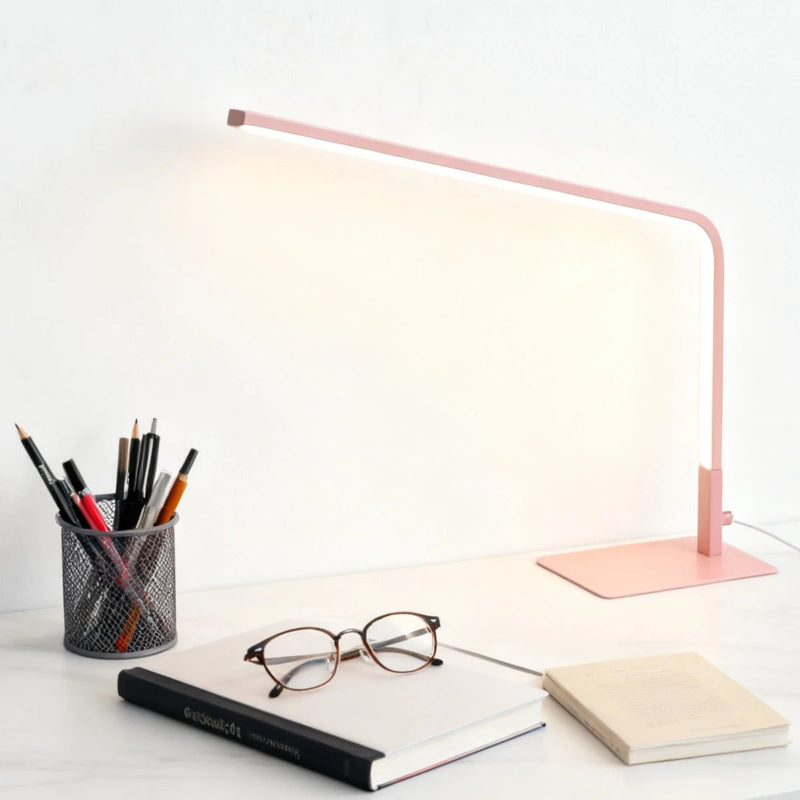 Lampe de Bureau LED USB Linea rose sur un bureau blanc