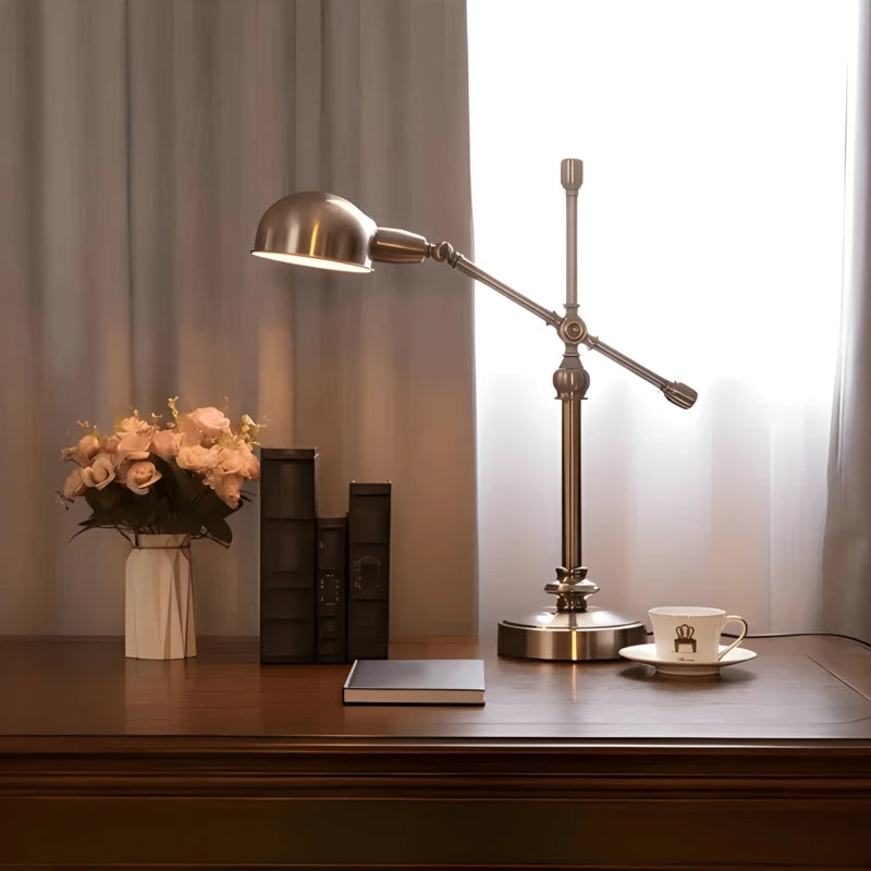 Lampe de bureau vintage cuivrée arrondie sur un large bureau en bois