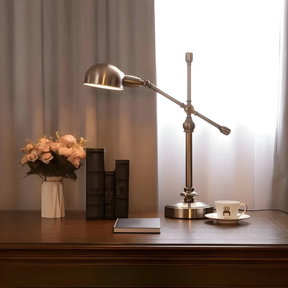 Lampe de bureau vintage cuivrée arrondie sur un large bureau en bois