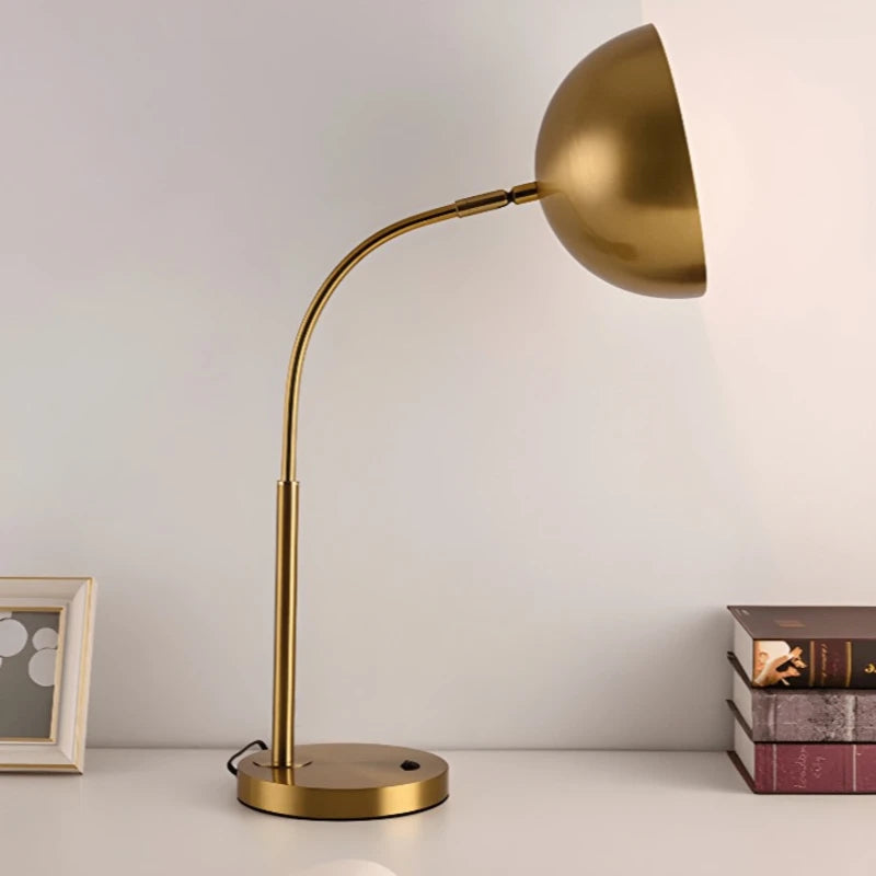 Lampe de bureau vintage dorée de profil qui éclaire le côté droit du  bureau