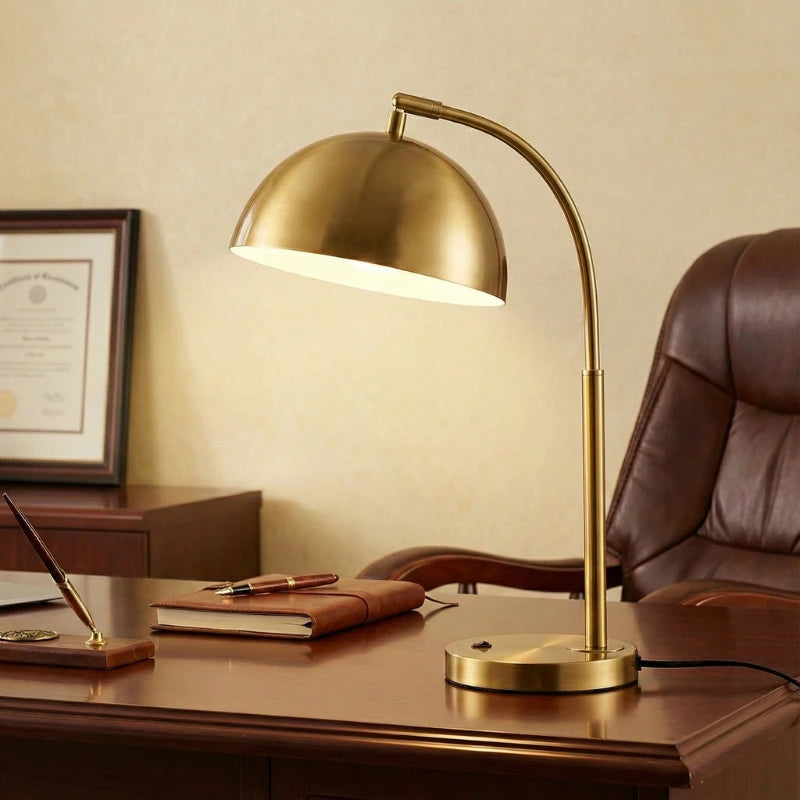 Lampe de bureau vintage dorée au-dessus d'un bureau en bois foncé 