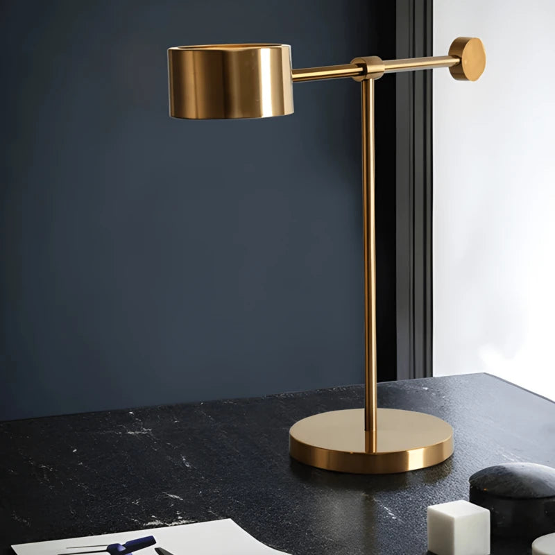 Lampe design T dorée sur un bureau en marbre