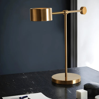 Lampe design T dorée sur un bureau en marbre
