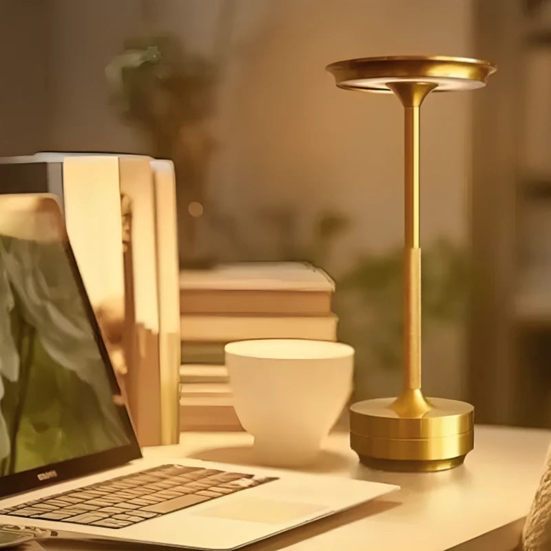 Lampe de bureau LED sans-fil dorée placée sur un espace de travail